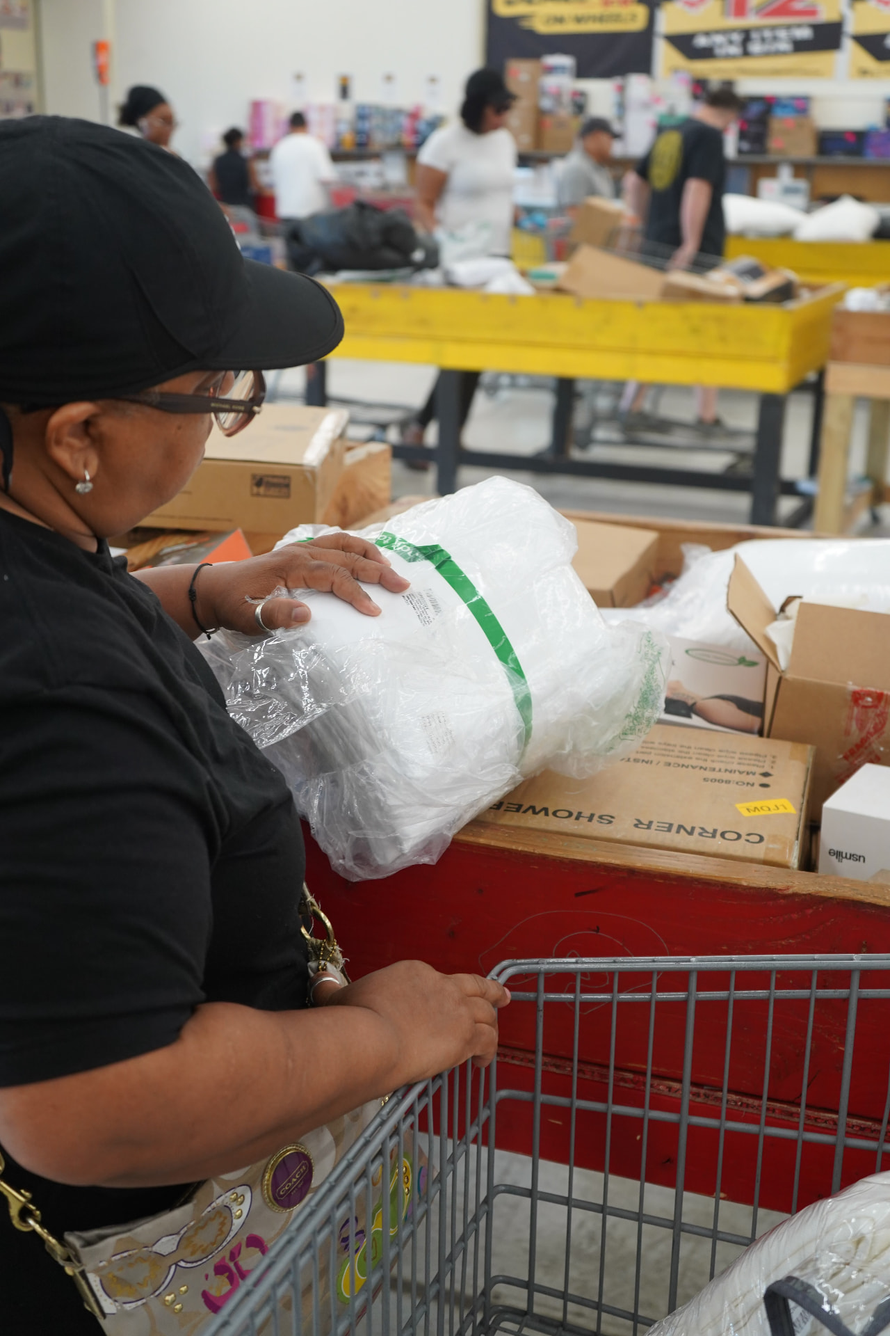 A shopper browsing merchandise bins at Deals on Wheels